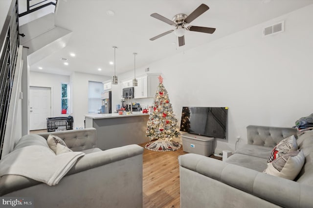 living room featuring ceiling fan and light hardwood / wood-style flooring