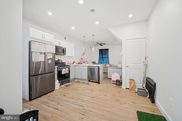 kitchen with kitchen peninsula, stainless steel appliances, ceiling fan, white cabinetry, and hanging light fixtures