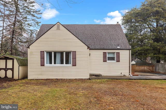 back of property with a patio, a storage unit, and a lawn