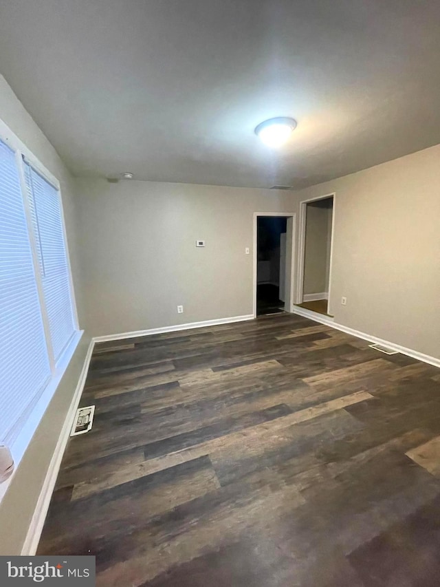 unfurnished room with dark hardwood / wood-style floors