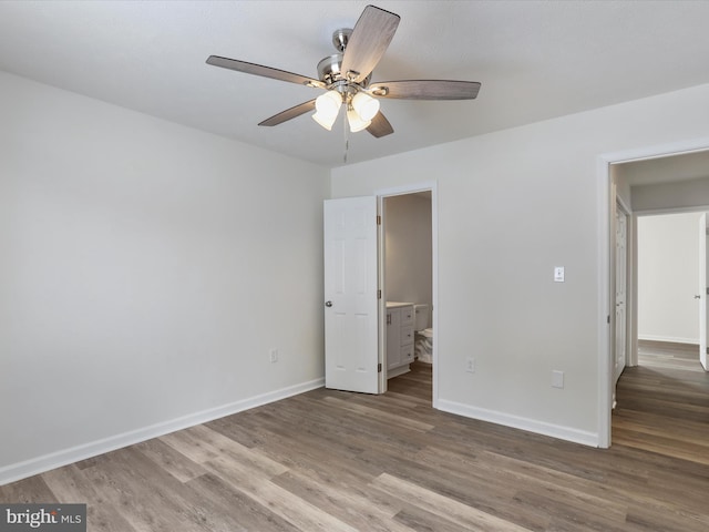 unfurnished bedroom featuring ensuite bath, ceiling fan, and wood-type flooring