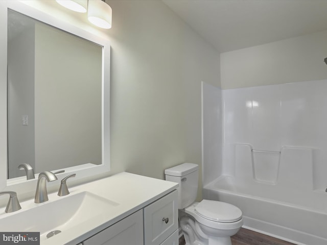 full bathroom featuring hardwood / wood-style flooring, vanity,  shower combination, and toilet