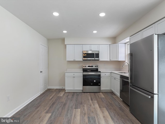 kitchen featuring sink, white cabinets, stainless steel appliances, and hardwood / wood-style flooring