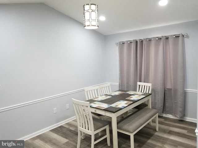 dining room with dark hardwood / wood-style floors and lofted ceiling