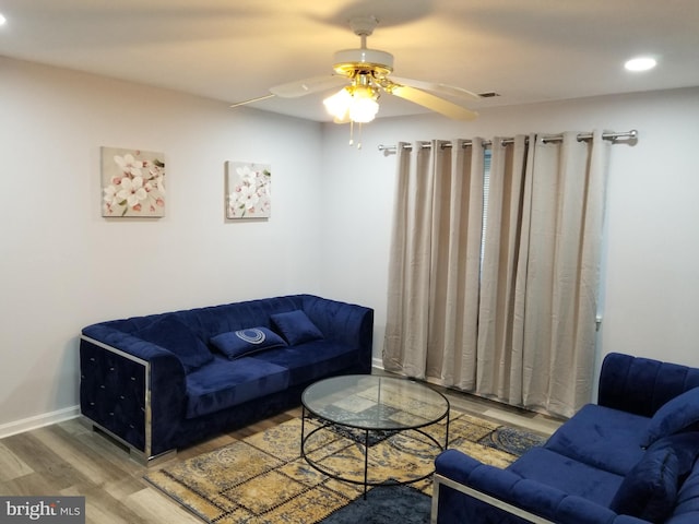 living room featuring wood-type flooring and ceiling fan