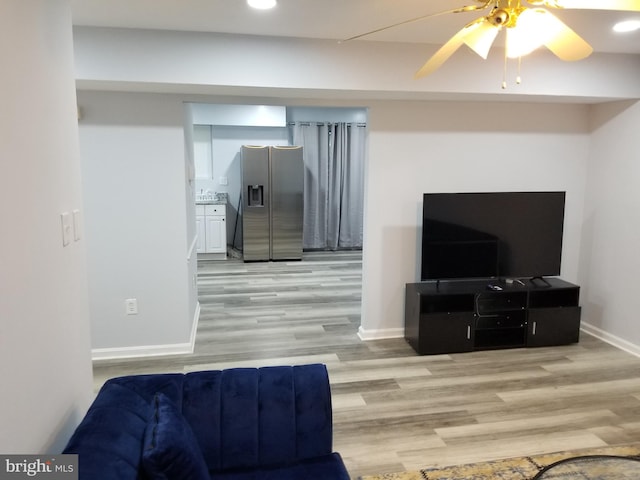 living room with light wood-type flooring and ceiling fan