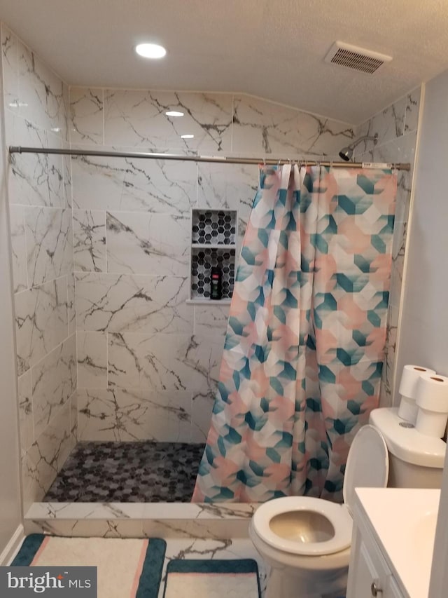 bathroom featuring a textured ceiling, vanity, toilet, and curtained shower