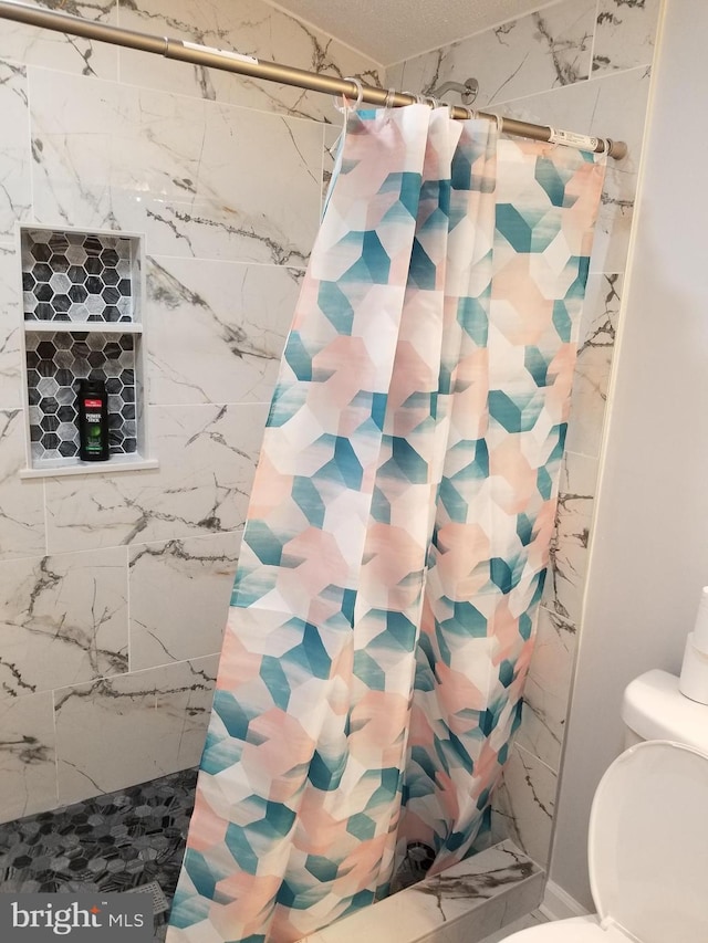 bathroom featuring curtained shower and toilet