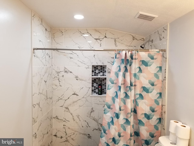 bathroom featuring a shower with curtain, a textured ceiling, and toilet