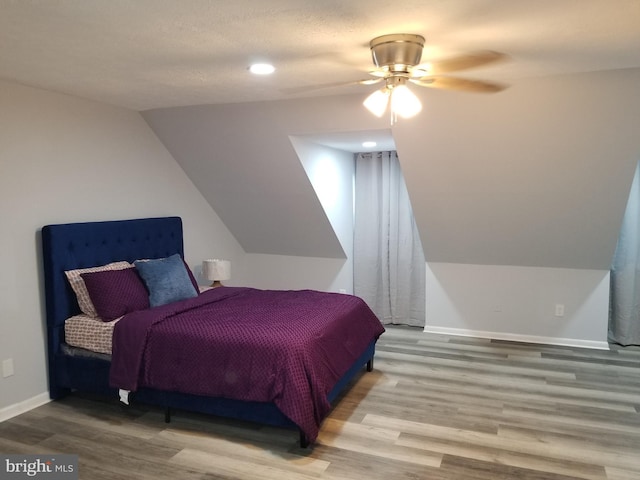 bedroom with ceiling fan, lofted ceiling, and hardwood / wood-style flooring