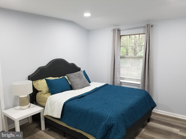 bedroom featuring hardwood / wood-style floors and lofted ceiling