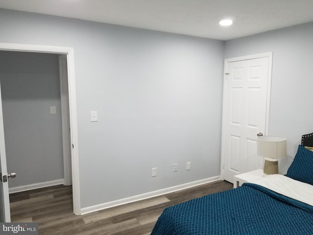 bedroom with dark wood-type flooring