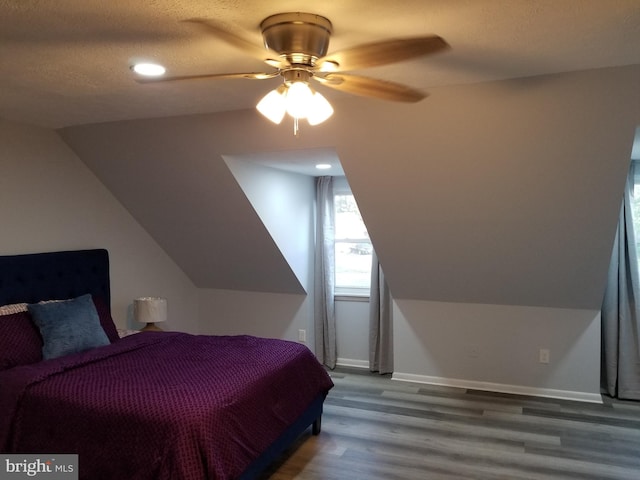 bedroom with wood-type flooring, a textured ceiling, ceiling fan, and lofted ceiling