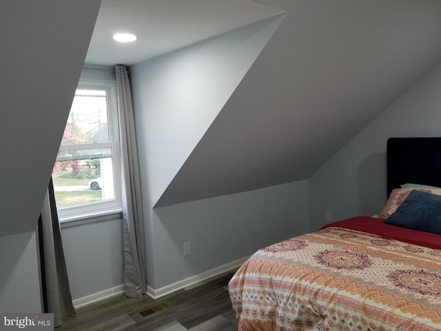 bedroom with dark hardwood / wood-style flooring and vaulted ceiling