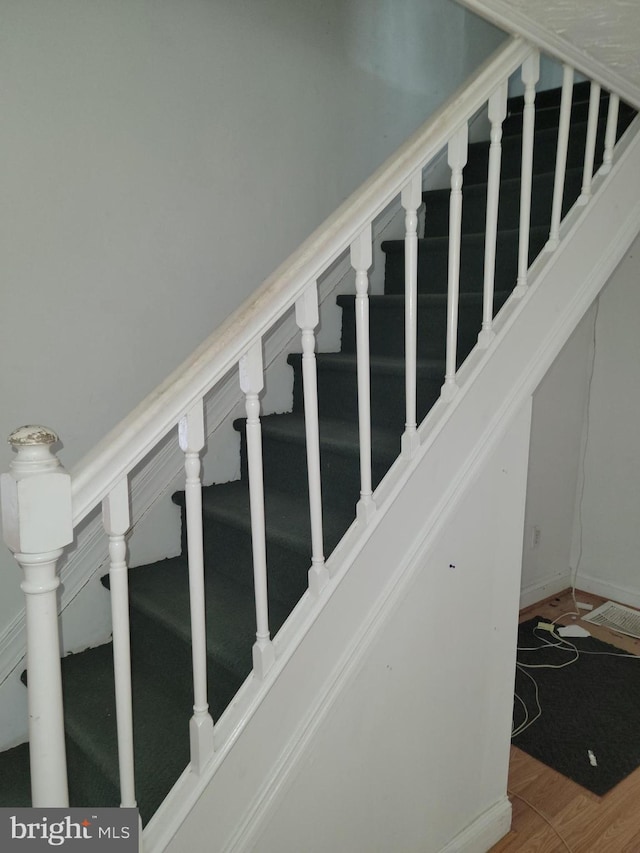 staircase with hardwood / wood-style floors