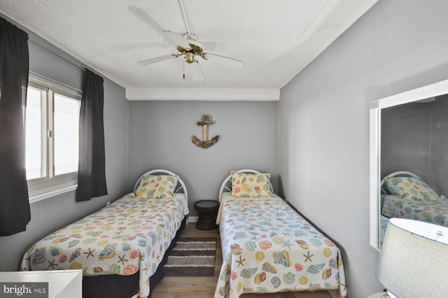 bedroom featuring hardwood / wood-style floors, a textured ceiling, and ceiling fan