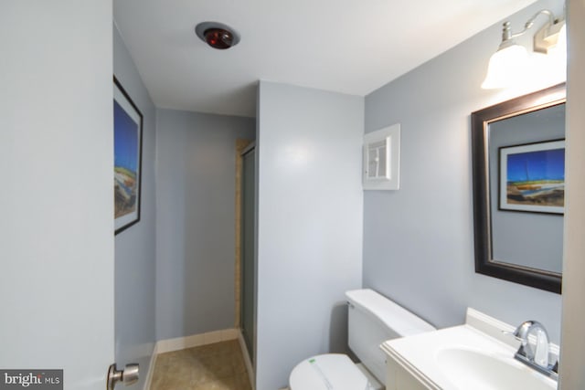 bathroom featuring toilet, vanity, tile patterned floors, and walk in shower