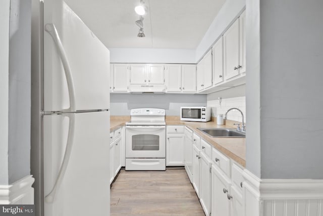 kitchen featuring white cabinetry, white appliances, sink, and light hardwood / wood-style flooring