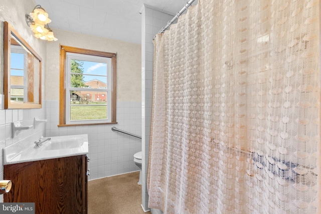 bathroom featuring vanity, toilet, tile walls, and curtained shower