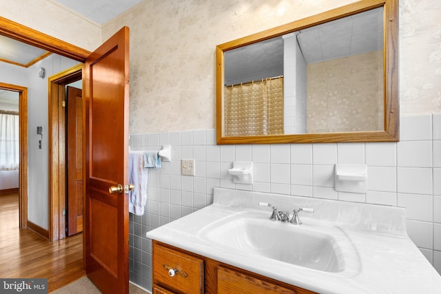 bathroom featuring wood-type flooring, vanity, and tile walls