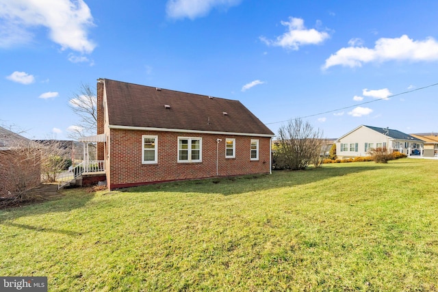 rear view of house featuring a yard