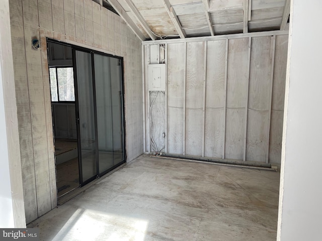 interior space featuring vaulted ceiling, concrete floors, and electric panel