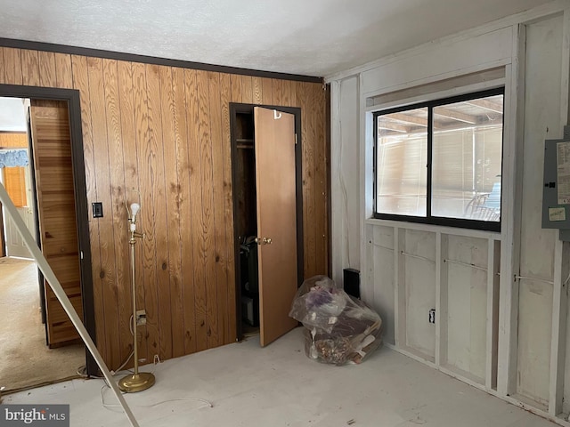 interior space featuring a textured ceiling and wooden walls