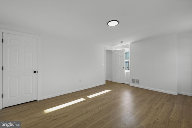 empty room with hardwood / wood-style flooring