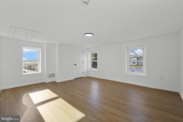 unfurnished room with hardwood / wood-style floors and a healthy amount of sunlight