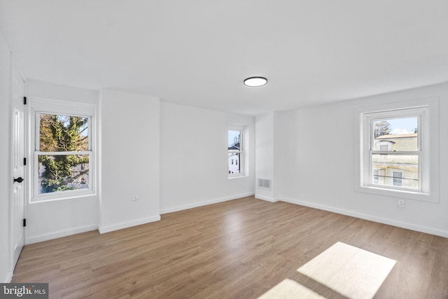 spare room with light hardwood / wood-style floors and a wealth of natural light