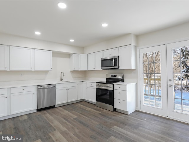 kitchen featuring appliances with stainless steel finishes, a healthy amount of sunlight, white cabinets, and sink