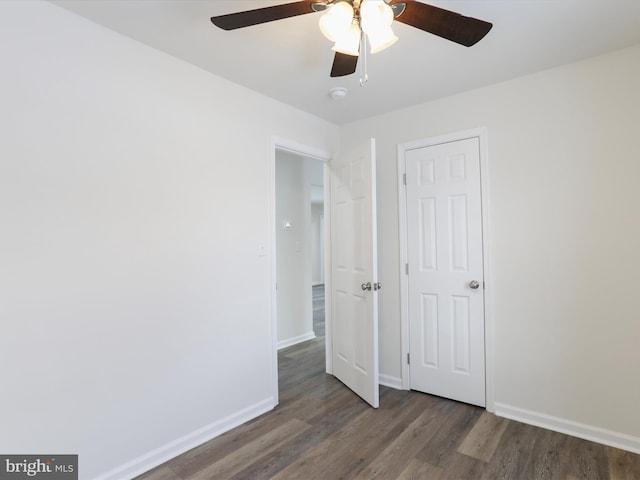 unfurnished bedroom featuring ceiling fan and dark wood-type flooring