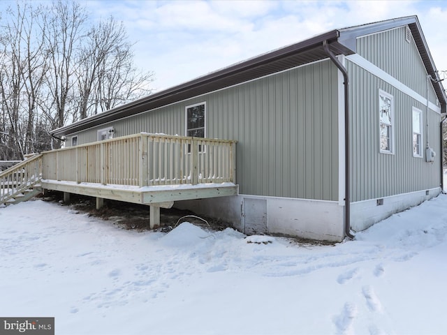 snow covered property with a deck