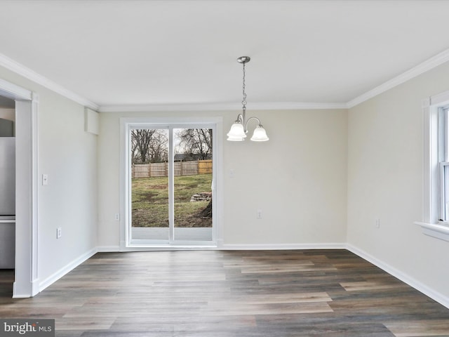 unfurnished dining area featuring an inviting chandelier, crown molding, and dark wood-type flooring