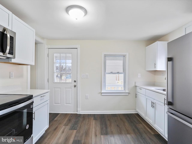 kitchen featuring stainless steel appliances, dark hardwood / wood-style floors, and white cabinets