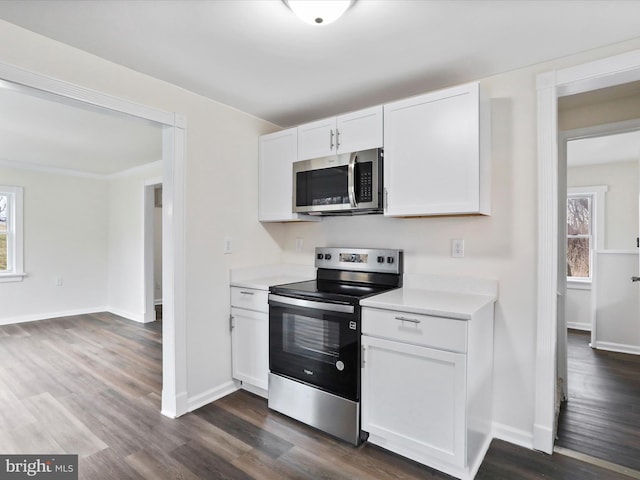 kitchen with white cabinetry, a healthy amount of sunlight, stainless steel appliances, and dark wood-type flooring