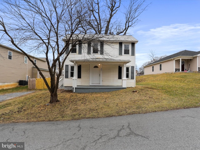 view of property with central AC unit, a front yard, and covered porch