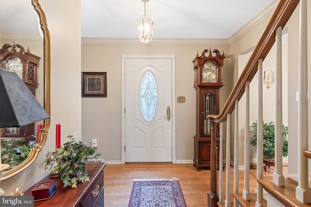 foyer featuring an inviting chandelier, crown molding, and light hardwood / wood-style flooring