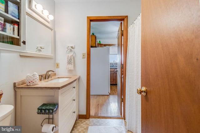 bathroom with hardwood / wood-style flooring, vanity, and toilet