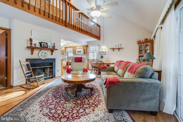 living room with ceiling fan, high vaulted ceiling, and wood-type flooring