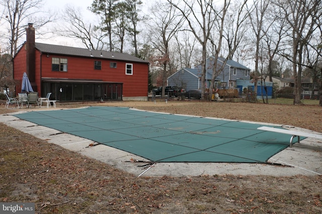 view of swimming pool with a diving board and a patio