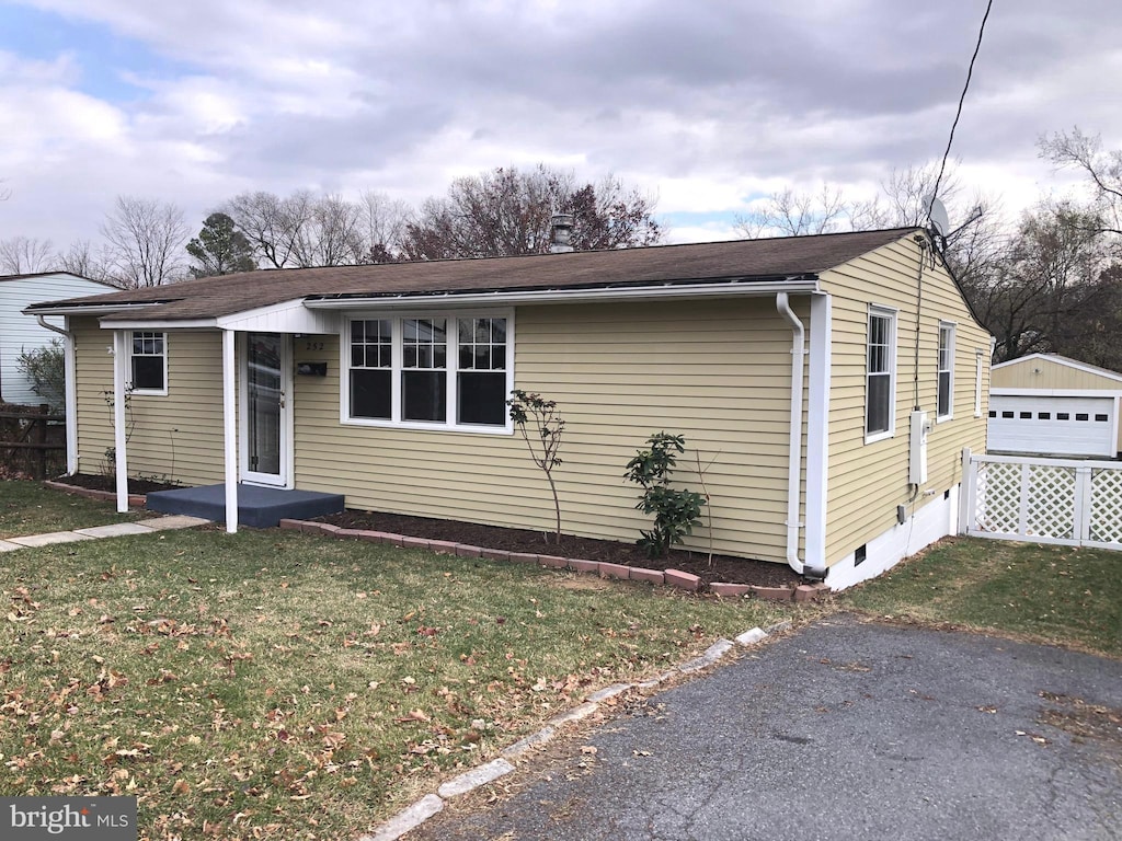 view of front of home with a garage, an outbuilding, and a front yard