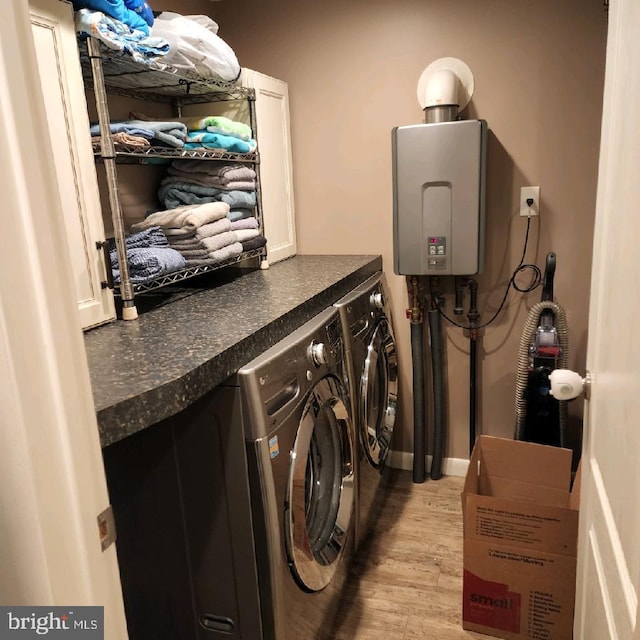 laundry area with tankless water heater, light wood-type flooring, and washing machine and clothes dryer