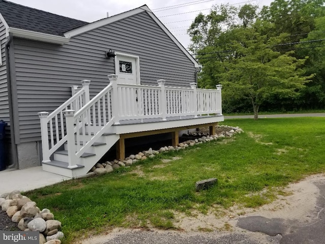 doorway to property with a yard and a wooden deck