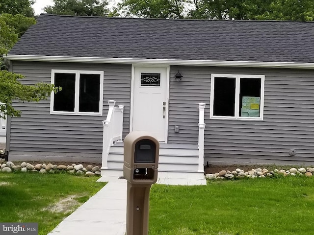 property entrance with a lawn