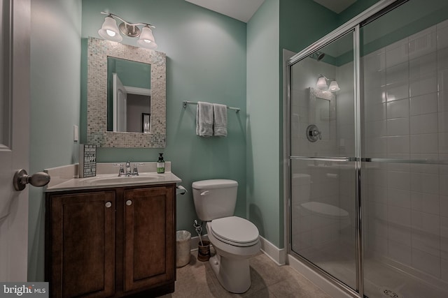 bathroom featuring tile patterned floors, toilet, vanity, and walk in shower