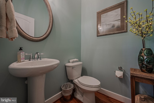 bathroom featuring wood-type flooring and toilet