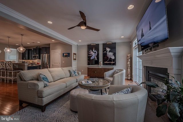 living room featuring dark hardwood / wood-style floors, ceiling fan, and ornamental molding