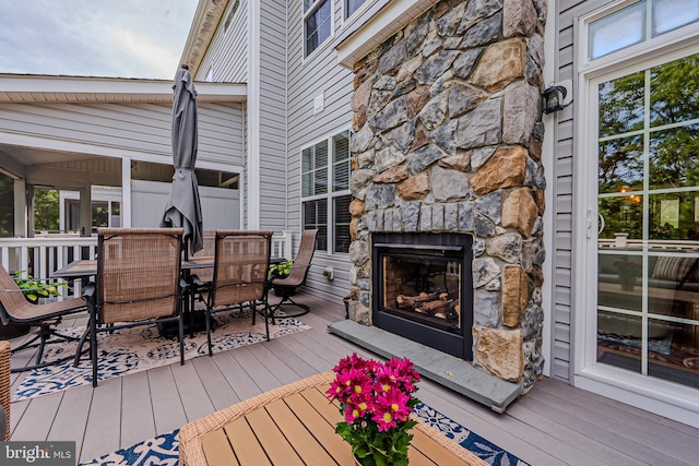 deck with an outdoor stone fireplace