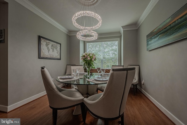 dining space with hardwood / wood-style flooring, ornamental molding, and a notable chandelier